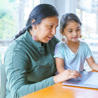 A learner with a child on their lap